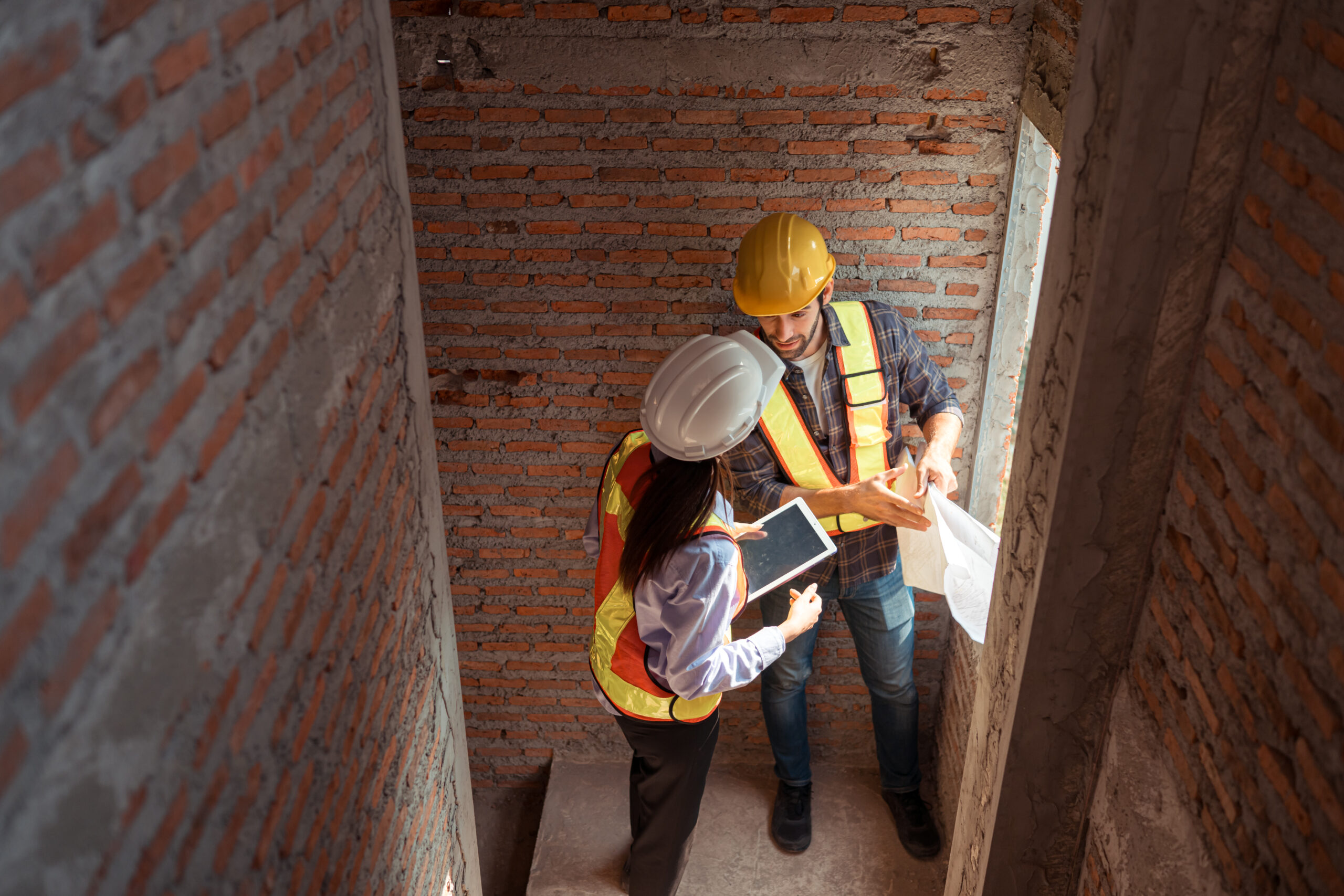 Architects and engineers work together to assess the residential home construction site's progress